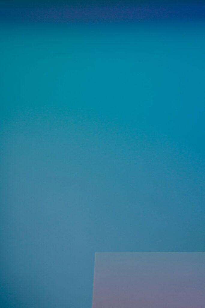 Minimalist image featuring a smooth blue gradient with a subtle geometric shape.